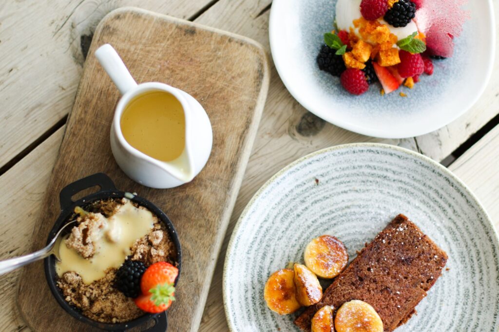 Puddings and custard on a wooden board