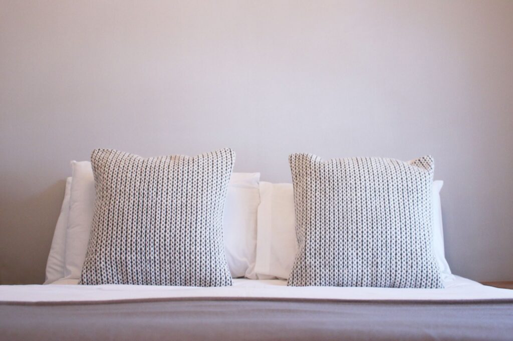 Crisp white bedding and knitted cushions